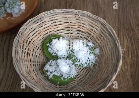 Lumpang cake or kue lumpang is a traditional cake from Indonesia, steamed soft green, chewy texture, served with coconut flakes served on bamboo baske Stock Photo