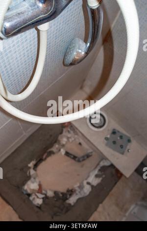 Shower Hose in Foreground with Bathroom Renovation Area in Background Stock Photo