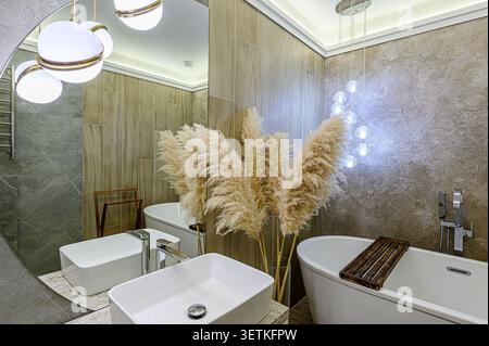 Elegant bathroom with modern fixtures. Pampas grass adds a touch of nature Stock Photo