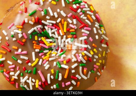 A top down view of a chocolate cake rainbow sprinkles donut. Stock Photo