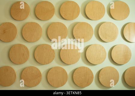A view of a pattern of wooden discs on a wall, as a background. Stock Photo