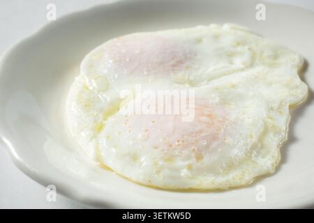 A view of over medium eggs, on a plate. Stock Photo