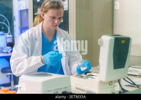 A focused scientist works diligently in a lab utilizing advanced technology to conduct important research and experiments. Stock Photo