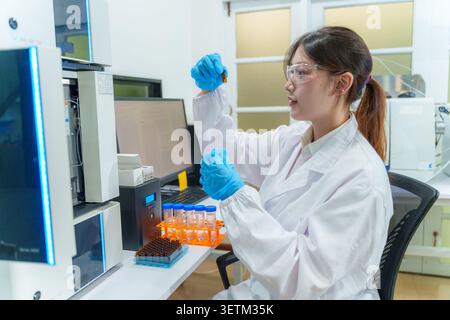 A dedicated female scientist examines a sample in a high tech lab showcasing the integration of technology in research. Stock Photo