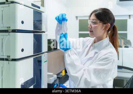 A dedicated female scientist examines a sample in a high tech lab showcasing the integration of technology in research. Stock Photo