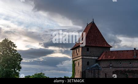 Historic medieval tower of Malbork Castle beneath dramatic storm clouds Stock Photo