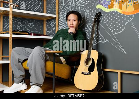 Casual attire highlights the young mans focus while he works in the creative space. Stock Photo