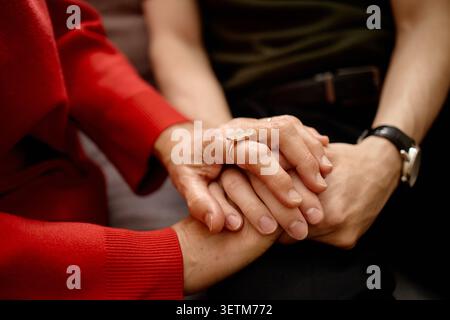 Middle Aged Woman Holding Hands with Adult Son in Emotional Support Session Stock Photo