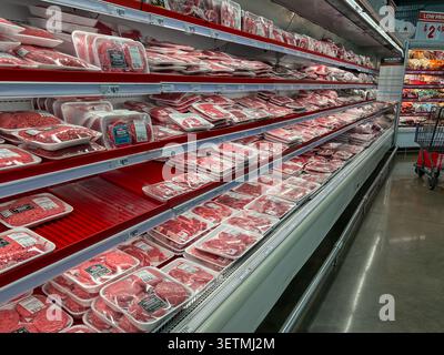 A variety of raw, packaged meat products on refrigerated shelves in a grocery store. Texas, USA Stock Photo