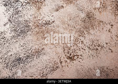 Rough plaster wall texture with pearlescent paint and soft metallic sheen. Earthy beige and brown abstract background suitable for design. Stock Photo