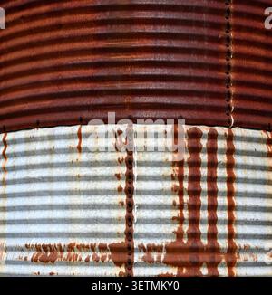 Close up of heavily rusted corrugated metal siding with arched ridges Stock Photo