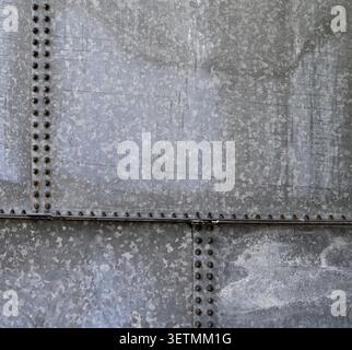 Horizontal close up of weathered galvanized steel water tank surface with two vertical seams, one horizontal seam Stock Photo