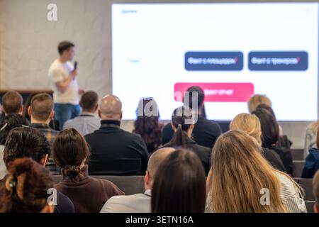 Group of professionals listening to speaker during business presentation, collaborative learning, networking atmosphere. Stock Photo