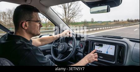 Man touching dashboard navigation screen while driving Stock Photo