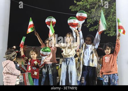 June 23, 2026, Tehran, Iran: Children hold small Iranian flags and balloons decorated in the colours of the national flag during a state-organized rally in Iran. The rally followed the June 18 signing of an interim memorandum of understanding by U.S. President Donald Trump and Iranian President Masoud Pezeshkian, aimed at ending the regional conflict that began with U.S.-Israeli strikes on Iran on February 28. On June 22, Washington temporarily eased sanctions on Iranian oil exports after U.S. Vice President JD Vance said Tehran had agreed to invite International Atomic Energy Agency inspector Stock Photo