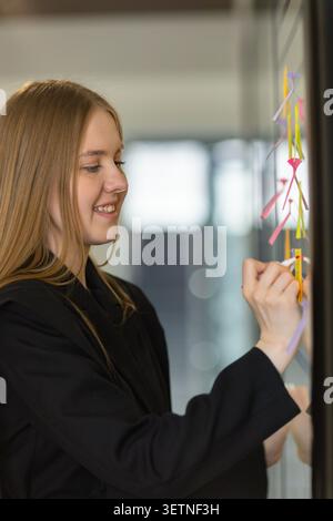 Smiling Businesswoman Planning Tasks with Sticky Notes Stock Photo