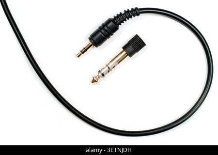 Headphone cable with 3.5 mm jack and 6.3 mm adapter. Close-up gold-plated audio jacks. Stock Photo