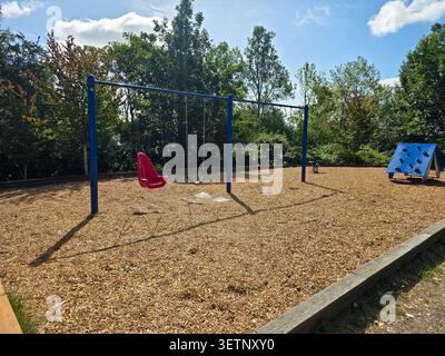 Playground Swing Set and Climbing Equipment in Public Park on Sunny Day Stock Photo