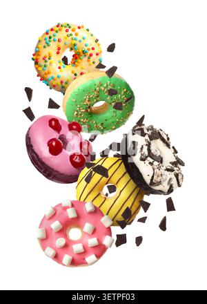 Tasty donuts and chocolate crumbs falling on white background Stock Photo