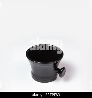 High angle close up shot of a glossy black porcelain gravy boat with a unique small handle, evoking a sense of premium culinary style and dark eleganc Stock Photo