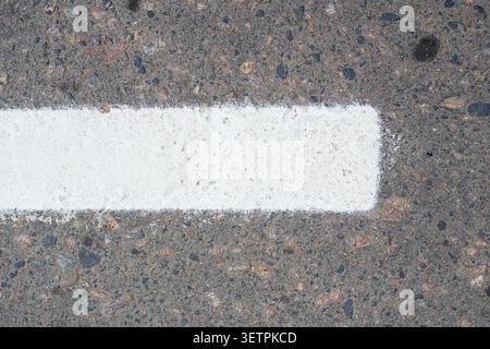 Fresh white dotted lane markings line the city's asphalt street. A close-up of the new road markings in the city, with selective focus on the surface Stock Photo