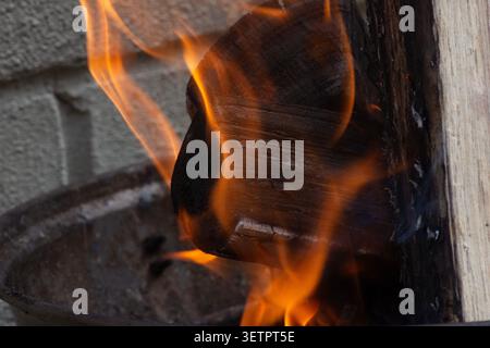 A close‑up photograph of bright orange flames rising against a dark background, showing detailed fire textures, glowing embers, and intense heat. Stock Photo