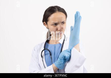 Woman putting on blue latex medical gloves Stock Photo