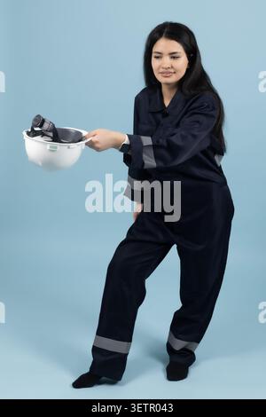 Female construction worker holding a white safety helmet Stock Photo