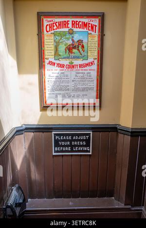 Vintage military poster to join the Cheshire Regiment and another poster "Please Adjust Your Dress Before Leaving" Stock Photo