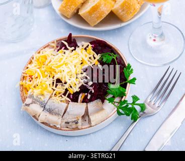 Pieces of herring with beetroot and cheese served on plate Stock Photo