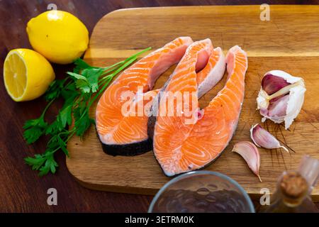 Salmon fillet on cutting board with lemon and parsley Stock Photo