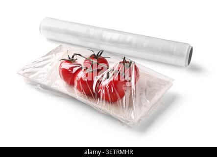 Fresh tomatoes wrapped in plastic cling film on tray Stock Photo