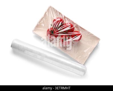 Fresh tomatoes wrapped in plastic film on tray with roll Stock Photo
