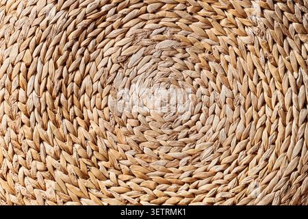 Close-up of woven natural straw mat texture in circular pattern Stock Photo