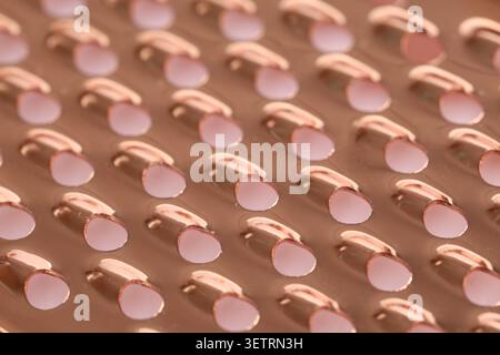 Close-up of copper metal surface with circular perforations Stock Photo