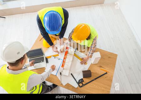Construction workers collaborating on building plans Stock Photo