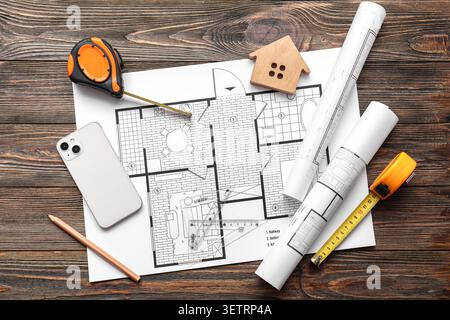 Architectural floor plan with measuring tools and wooden house model on wooden table Stock Photo