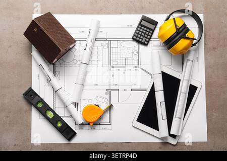 Architectural blueprints with measuring tools and model house on table Stock Photo