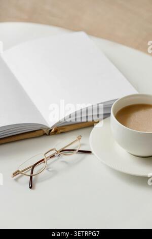 Open blank book with glasses and cup of coffee on table Stock Photo