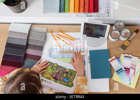 Interior designer working on house plan with fabric swatches and color samples Stock Photo