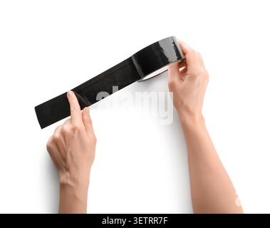 Hands holding and unrolling black adhesive tape on white background Stock Photo