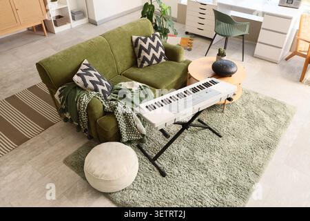 Interior of living room with sofa, glucophone and synthesizer Stock Photo