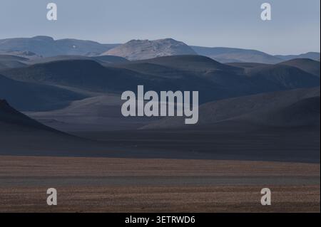 Dark volcanic mountains and black desert landscape along Sprengisandsleið in the Icelandic Highland under dramatic clouds Stock Photo