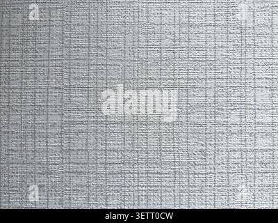 A close-up view of a fine grid linen-textured wallpaper in a cool silver-gray tone, filling the entire frame with a uniform woven pattern. Stock Photo