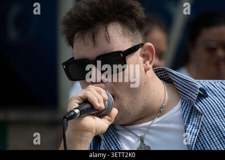 Young Cuban man with Down syndrome singing into a microphone during a unique social project performance in Ciego de Avila, Cuba Stock Photo