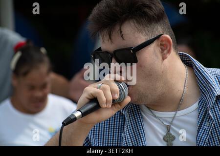 Young Cuban man with Down syndrome singing into a microphone during a unique social project performance in Ciego de Avila, Cuba Stock Photo