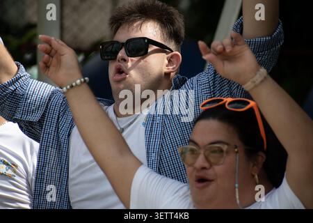Expressive young Cuban man and woman with Down syndrome celebrating with arms raised during a musical activity for the "Únicos y Brillantes" social pr Stock Photo