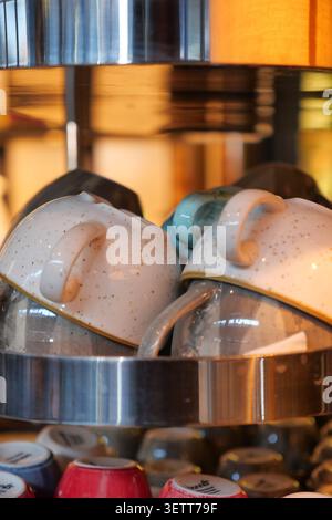 Cups stacked on a shelf in a kitchen area Stock Photo