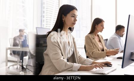 Asian office manager, customer support services employee working on computer Stock Photo