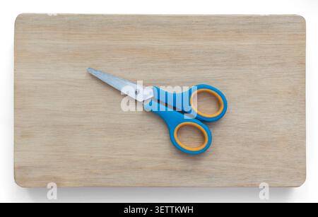 Blue and Yellow Scissors on Wooden Board Stock Photo